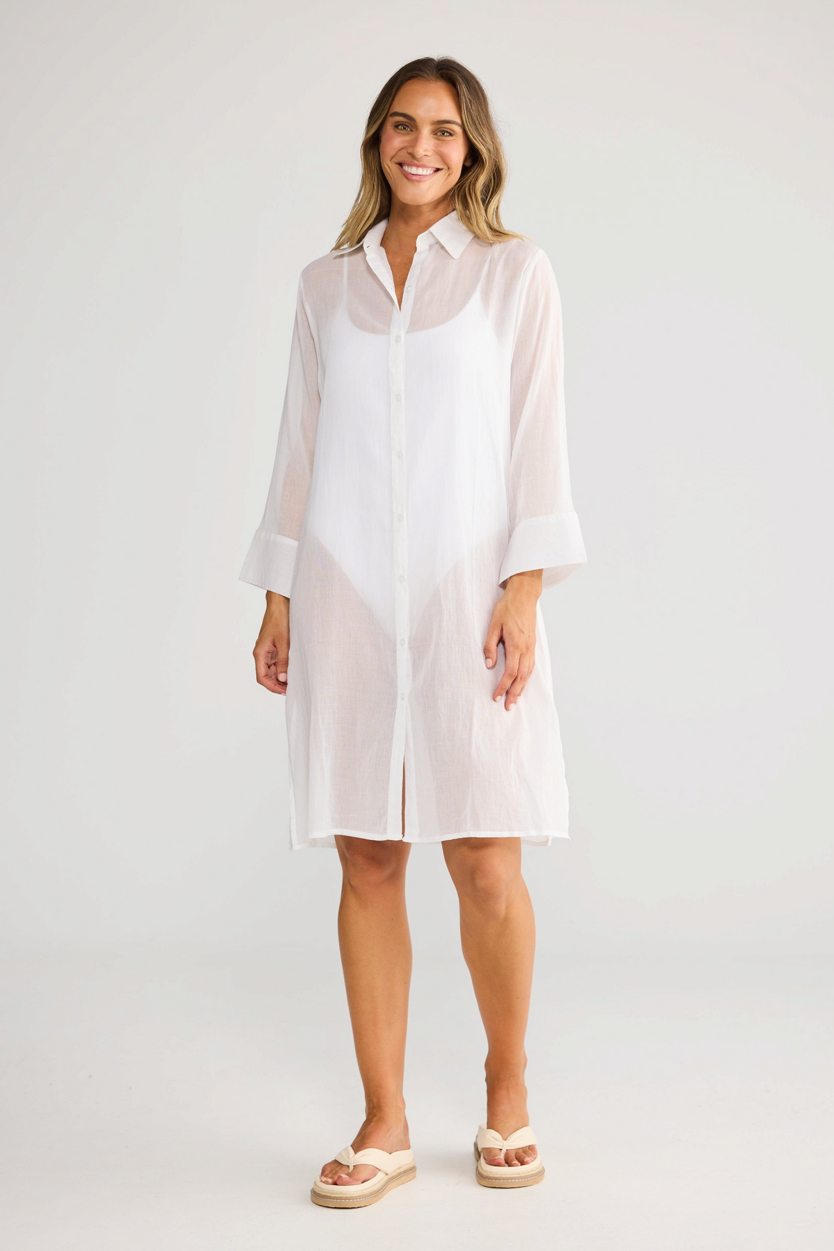 ELSHAM BOUTIQUE white cotton shirt dress with short sleeves and button front, worn by a smiling model.