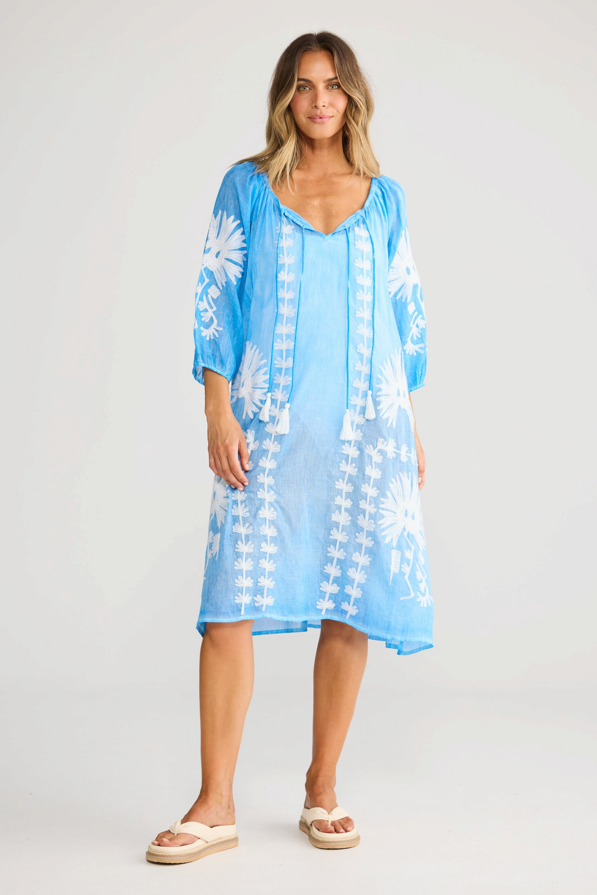 ELSHAM BOUTIQUE blue cotton knee-length dress with white floral embroidery, three-quarter sleeves, and front tie neck.