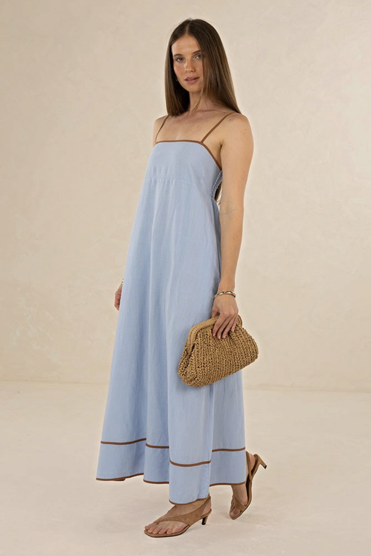 Model wearing ELSHAM BOUTIQUE blue and tobacco linen-blend midi dress with contrast trim and strappy neckline