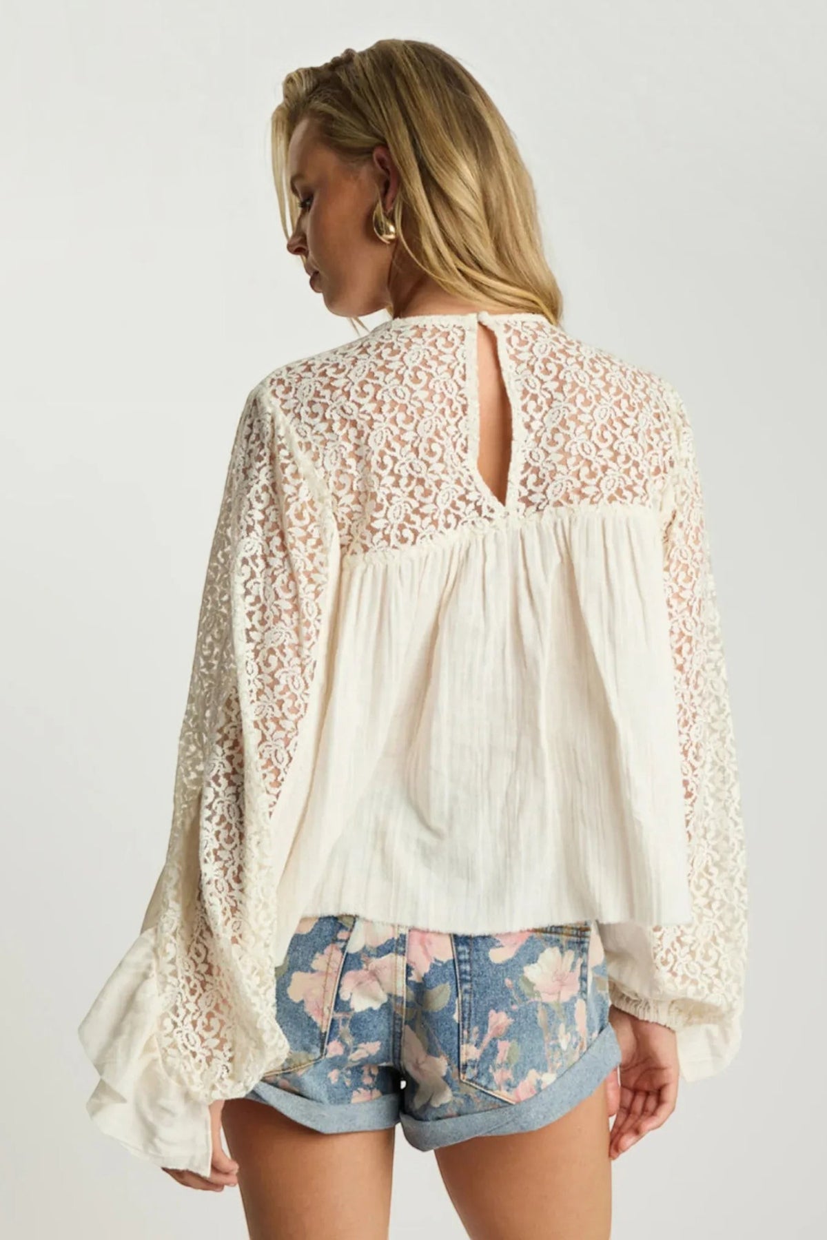 ELSHAM BOUTIQUE floral print denim shorts with rolled hem paired with a cream lace long sleeve blouse