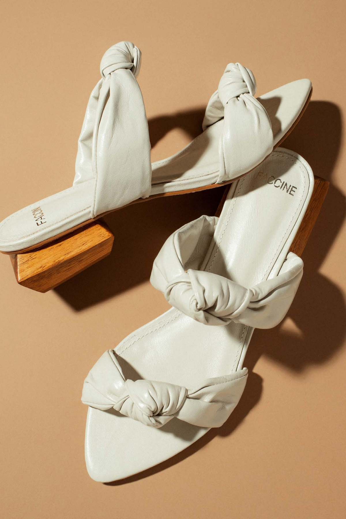 ELSHAM BOUTIQUE off-white leather slide sandals with knotted straps and a unique geometric wooden block heel.