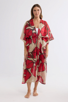 ELSHAM BOUTIQUE Asta long cotton kaftan in crimson floral print with an adjustable waist tie on a model