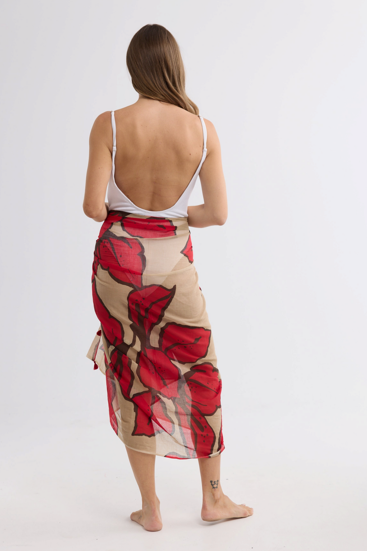 ELSHAM BOUTIQUE Stella sarong scarf in crimson floral print cotton worn by a model against a white background