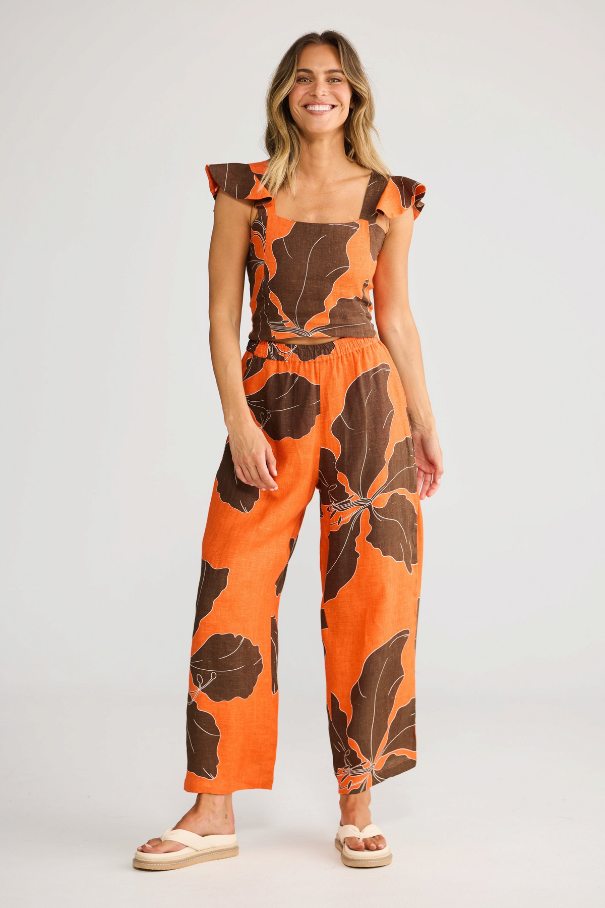 ELSHAM BOUTIQUE Zaria Top in Hibiscus Breeze orange linen gauze with square neckline and ruffle sleeves on a model