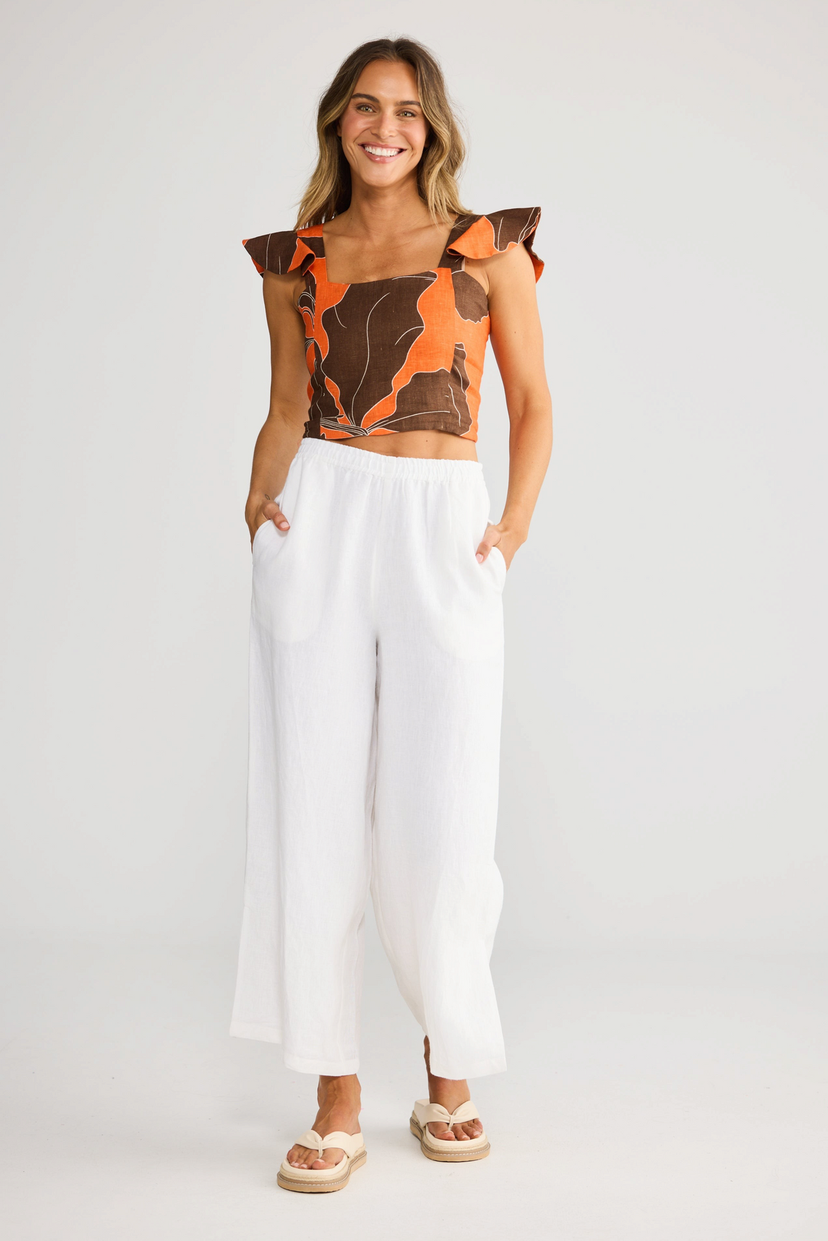 ELSHAM BOUTIQUE Zaria top in hibiscus breeze linen gauze with square neckline and ruffle sleeves on a smiling model