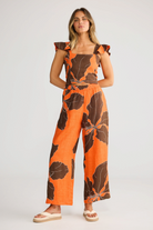 ELSHAM BOUTIQUE Zaria Top in orange and brown hibiscus print linen gauze with a square neckline and ruffle sleeves.