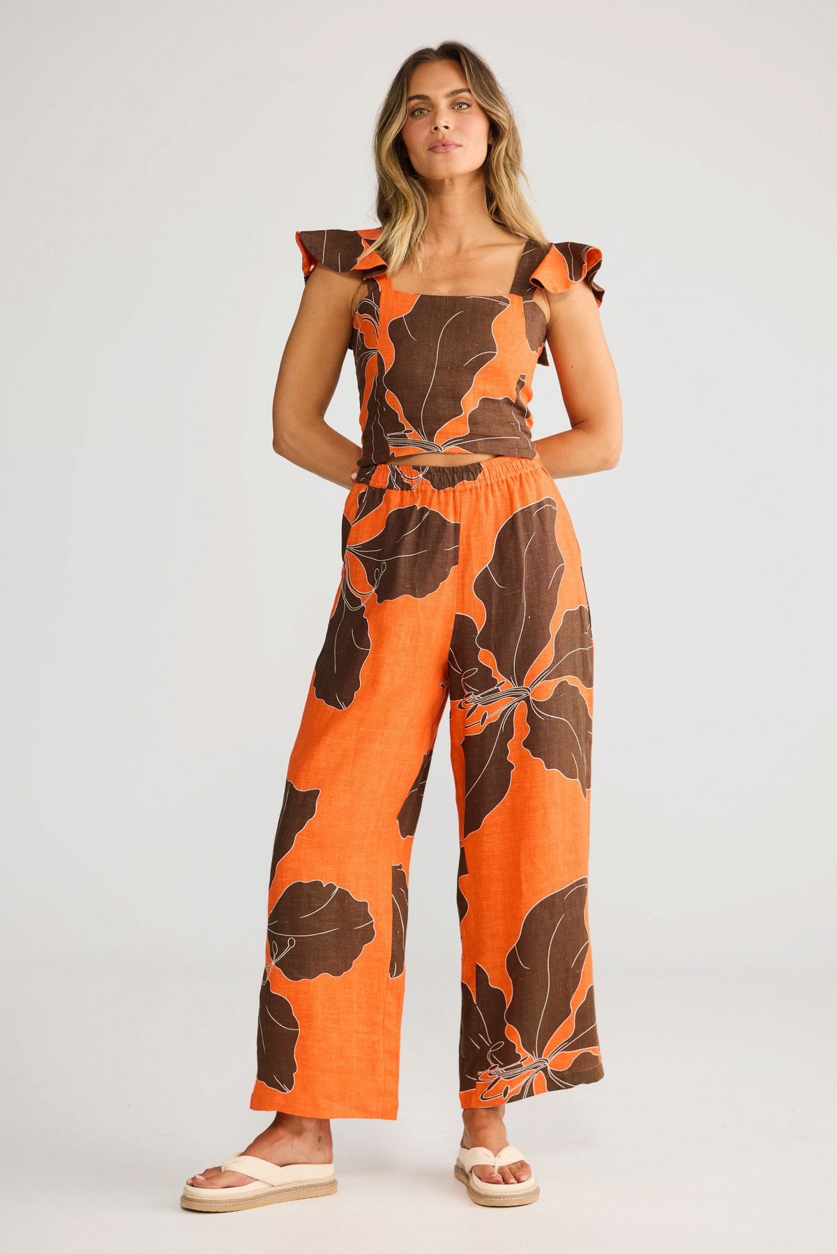 ELSHAM BOUTIQUE Zaria Top in orange and brown hibiscus print linen gauze with a square neckline and ruffle sleeves.