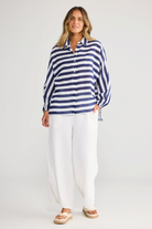 Model wearing ELSHAM BOUTIQUE navy and white striped oversized linen shirt with button front and elasticated cuffs