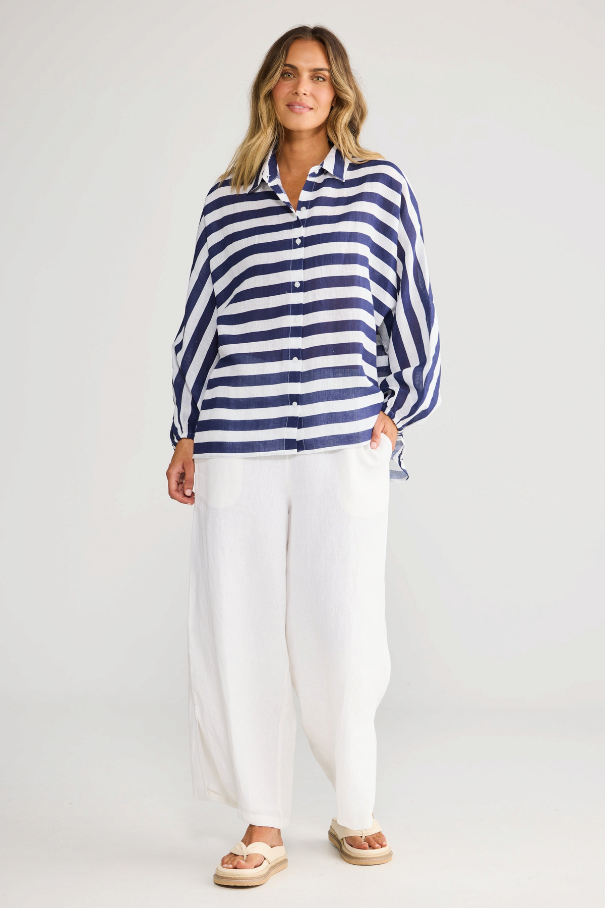 Model wearing ELSHAM BOUTIQUE navy and white striped oversized linen shirt with button front and elasticated cuffs