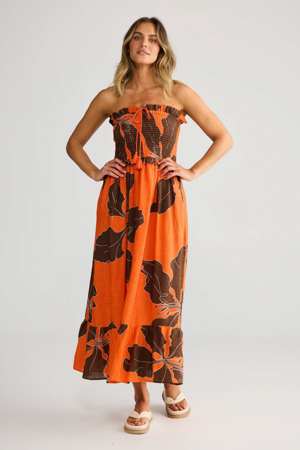 ELSHAM BOUTIQUE Sorrel strapless linen midi dress in orange Hibiscus Breeze floral print with rouching and frills.