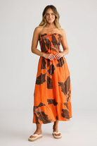 ELSHAM BOUTIQUE Sorrel strapless linen midi dress in orange and brown floral print with rouching and frill details.
