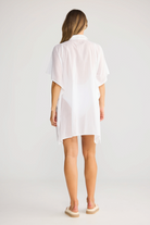 Back view of a woman wearing an ELSHAM BOUTIQUE white cotton shirt kaftan with short sleeves and a relaxed fit.