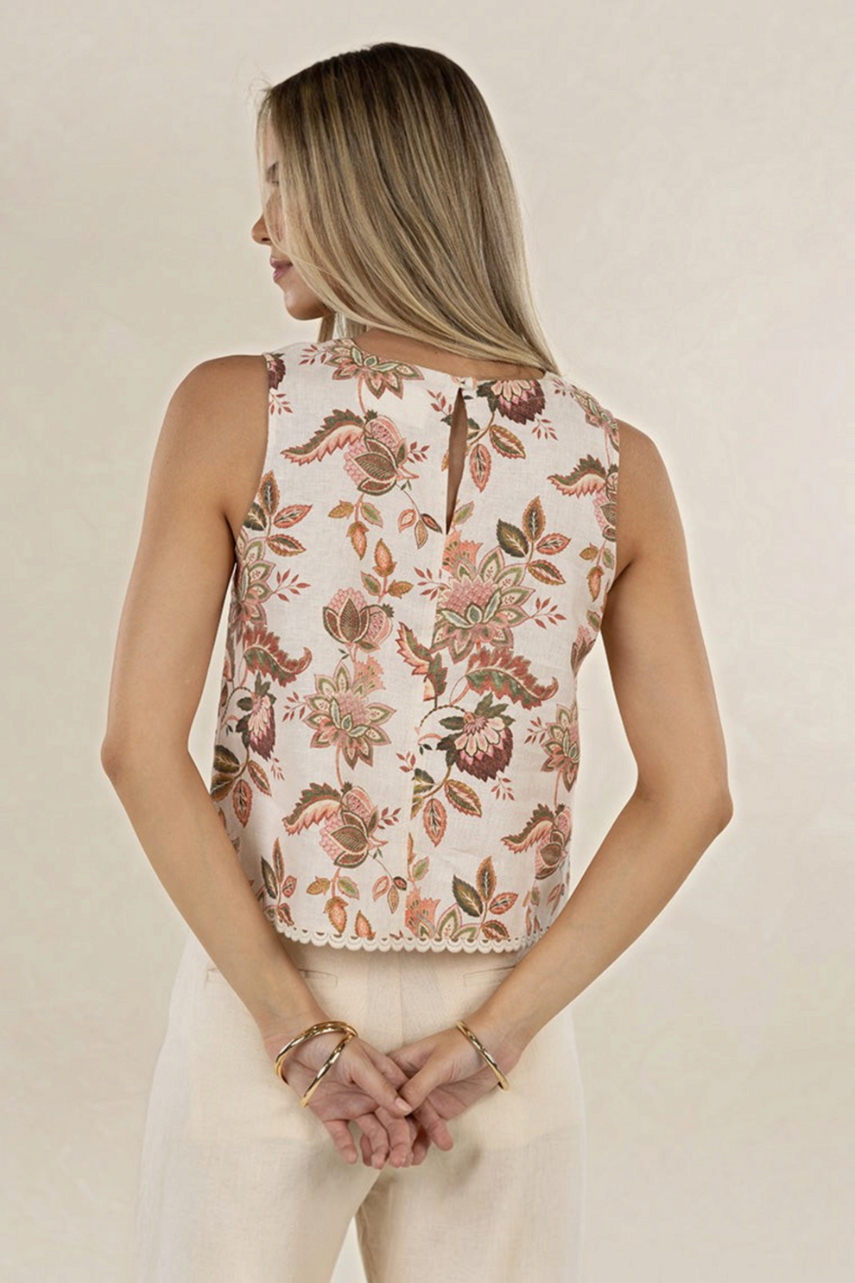 Model wearing ELSHAM BOUTIQUE sleeveless linen top in Bohemian Rose print with scalloped lace hem, back view.