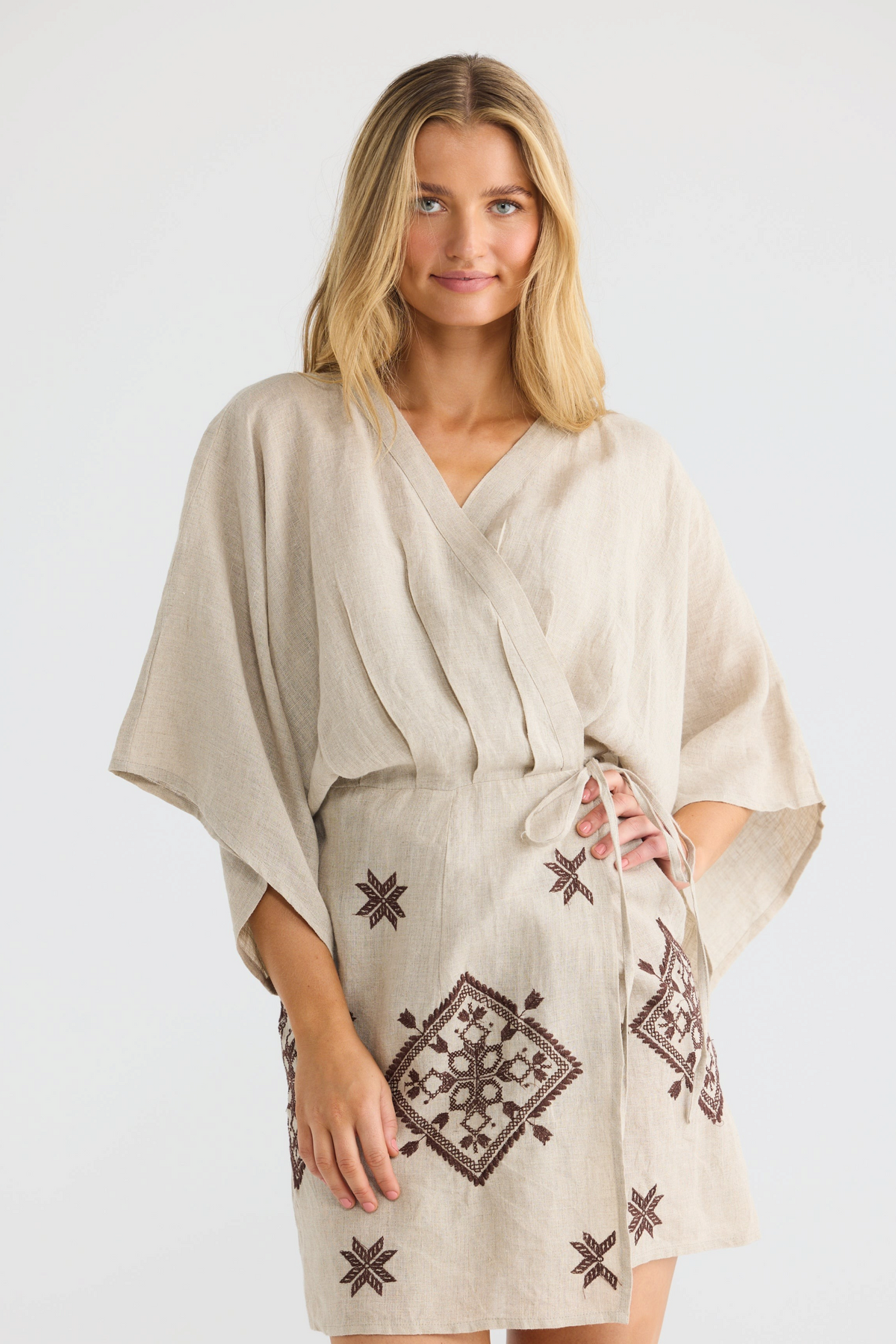 ELSHAM BOUTIQUE natural linen wrap dress with kimono sleeves, V-neckline, and brown embroidered geometric patterns.