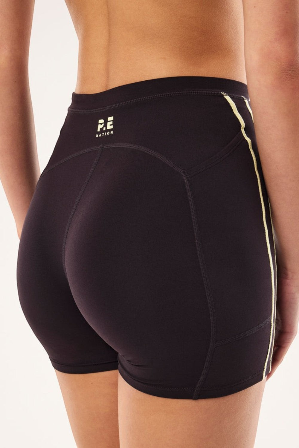 ELSHAM BOUTIQUE Cypher bike shorts in black with soft yellow contrast flatlock stitching and P.E Nation logo detail.