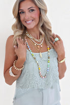 ELSHAM BOUTIQUE Glitterbelle necklace featuring peach and pastel crystals on antique gold plated brass worn by a model