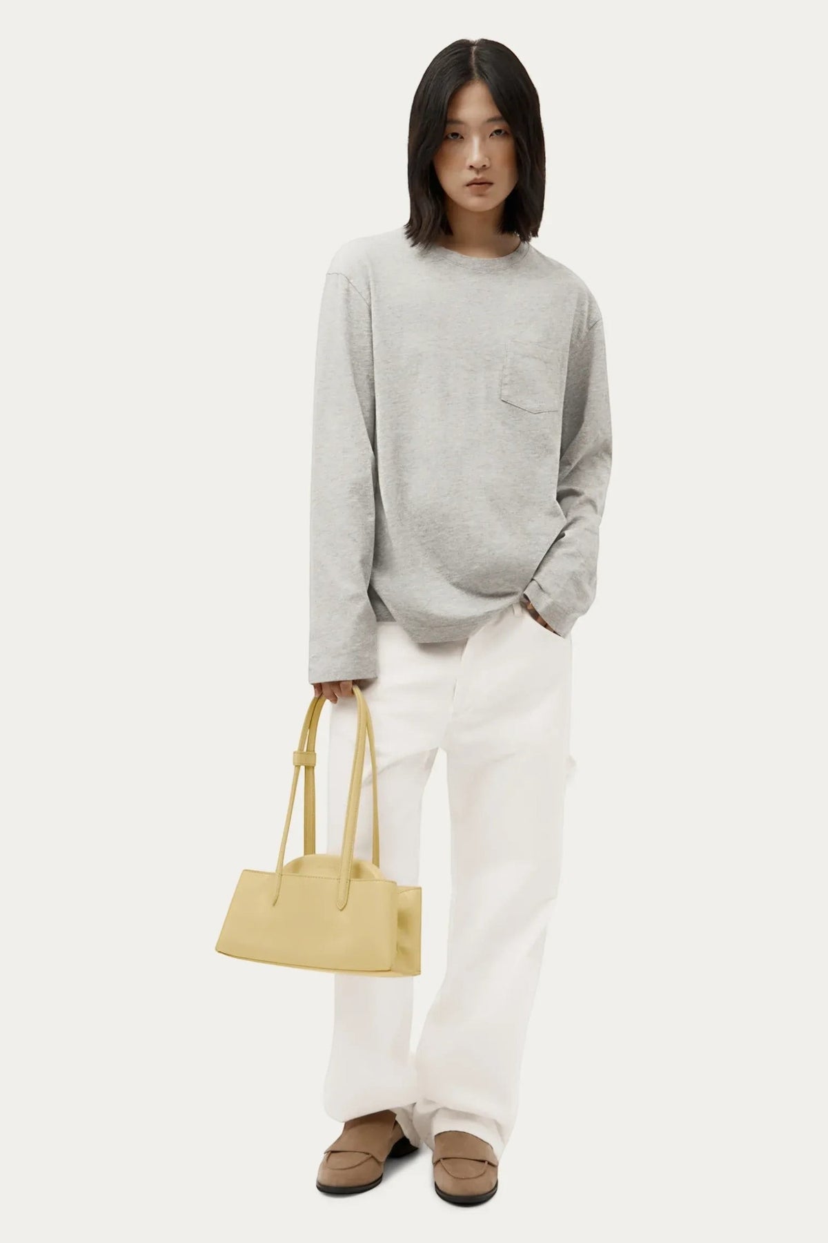 ELSHAM BOUTIQUE Mini Vault Tote in lemonade yellow calf nappa leather held by a model in a casual outfit