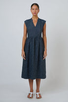 ELSHAM BOUTIQUE navy pinstripe linen midi dress with V-neck, cap sleeves, and drop gathered waist on a model.