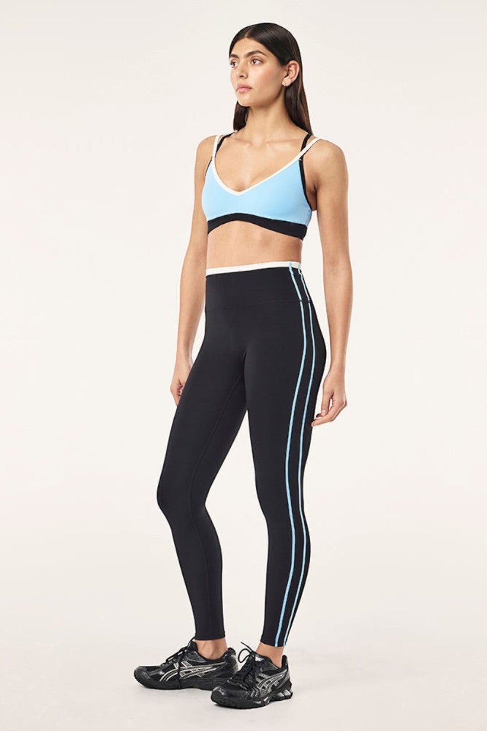 Model wearing ELSHAM BOUTIQUE Radar full length leggings in black with Alaskan blue side stripes and high waistband.