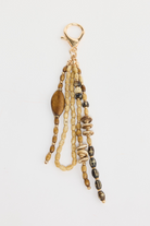 ELSHAM BOUTIQUE natural tribal keyring with beaded strands, wooden accents, and gold-tone metal clip.