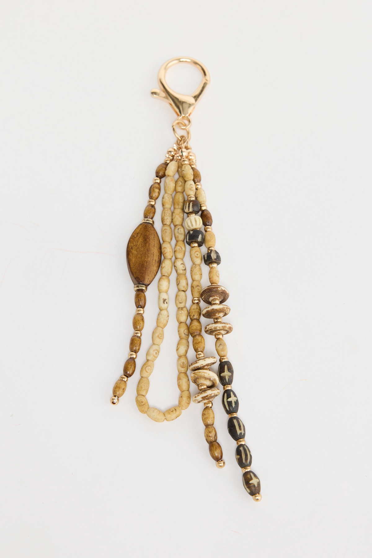ELSHAM BOUTIQUE natural tribal keyring with beaded strands, wooden accents, and gold-tone metal clip.